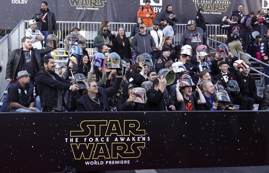 epa05069559 Fans lift their helmets while watching the red carpet during the arrivals for the premiere of 'Star Wars: The Force Awakens' at the TCL Theatre in Hollywood, California, USA, 14 December 2015. The film is the seventh in the Star Wars series.  EPA/EUGENE GARCIA