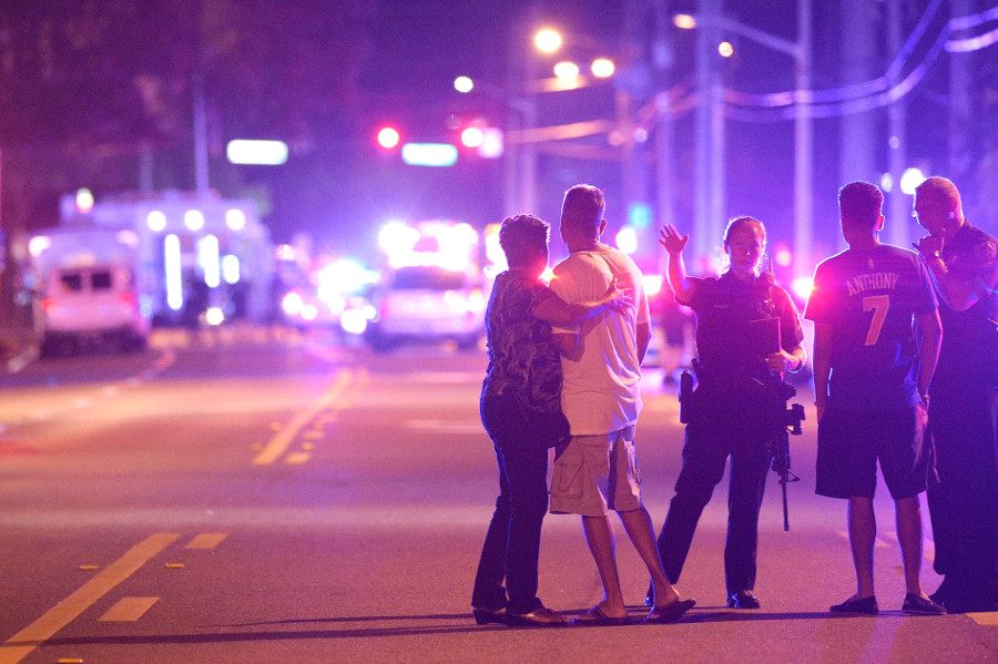 Orlando Police officers direct family members away from a fatal shooting at Pulse Orlando nightclub in Orlando, Fla., Sunday, June 12, 2016. (AP Photo/Phelan M. Ebenhack)